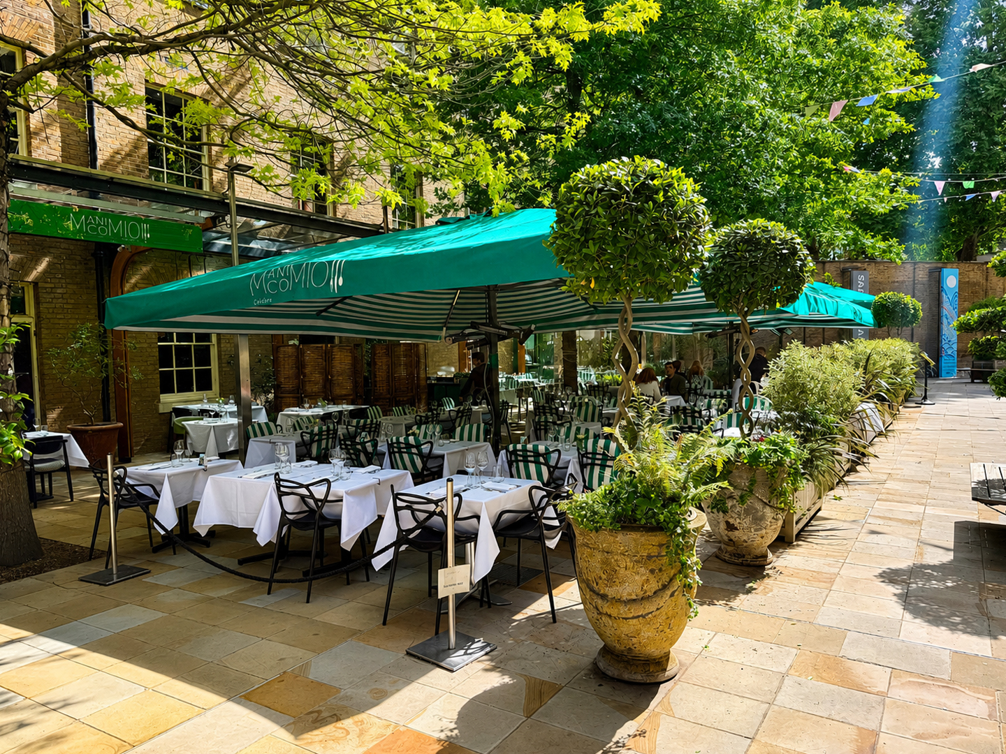 Manicomio outdoor courtyard dining area providing covered al fresco seating for restaurant guests.