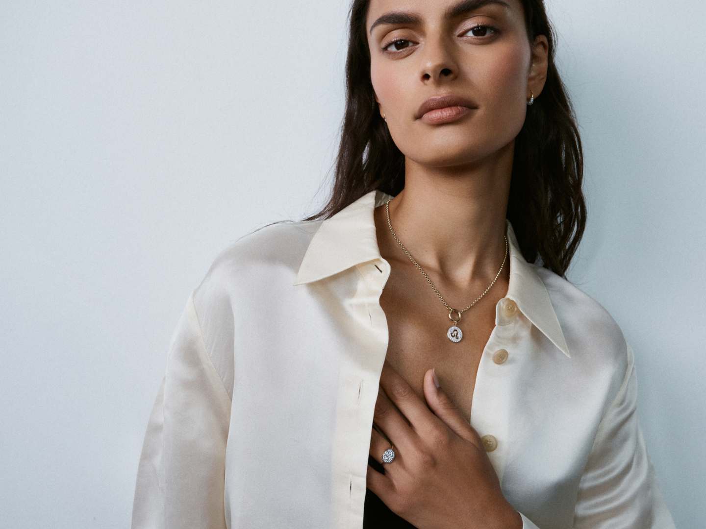 Model showcasing Otiumberg pendant necklace and ring
