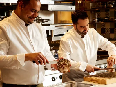 Two chefs demonstrating seafood preparation during a cooking masterclass at The Cadogan
