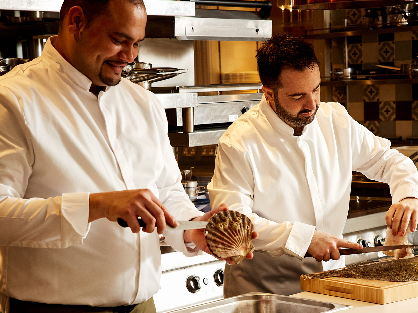 Two chefs demonstrating seafood preparation during a cooking masterclass at The Cadogan