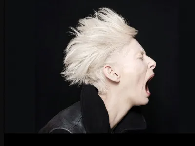 Side-profile portrait of a person mid-scream conveying intensity and motion.
