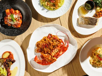 Assorted plated pasta and seafood dishes arranged for a shared restaurant meal.